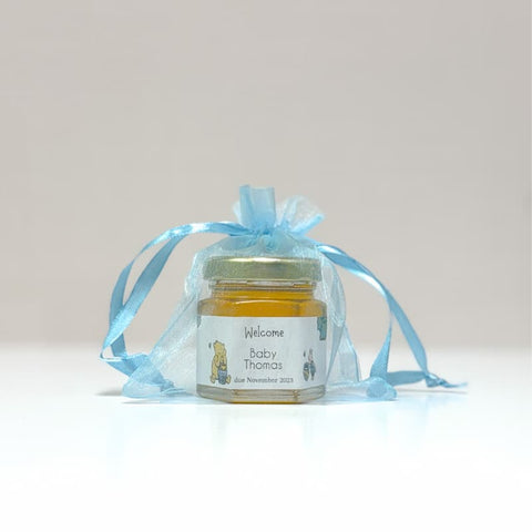 Jar of honey in a transparent blue bag on a light gray background