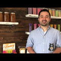 Video of man standing in front of various honey products on shelves explaining how to open a honey stick