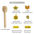 Collection of honey-related accessories including a wooden dipper, metal charms, and decorative elements on a white background.