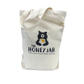 Canvas tote bag with 'The Honey Jar' logo on a white background