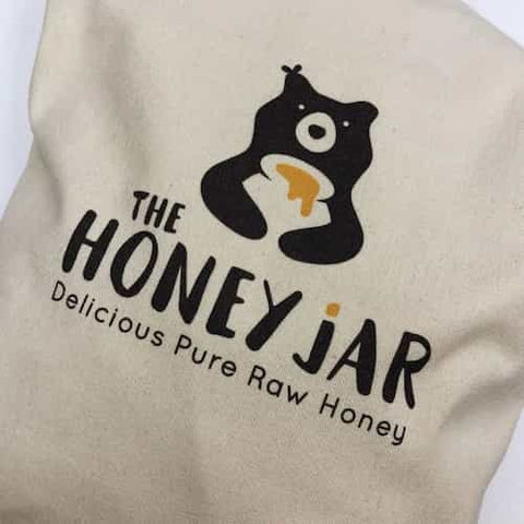 Beige fabric with 'The Honey Jar' logo featuring a bear and text.
