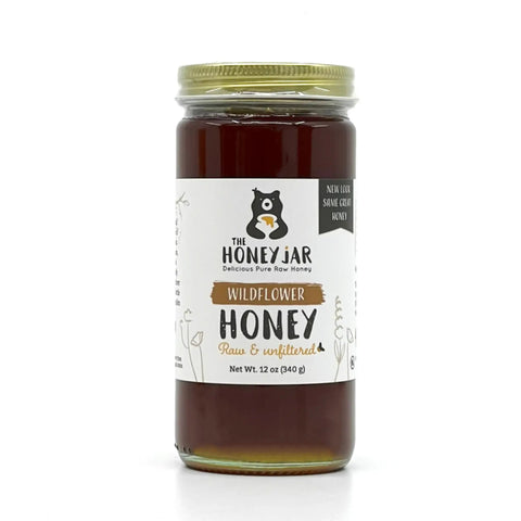 Jar of wildflower honey with a label on a white background