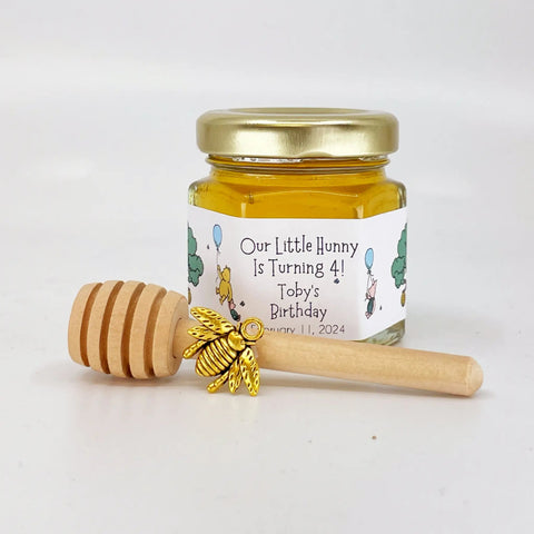 Jar of honey with a personalized label and honey dipper on a white background