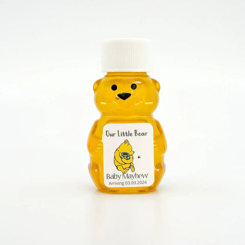 Yellow bear-shaped honey container with a white cap on a white background