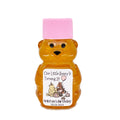 Bear-shaped honey bottle with pink cap and personalized label on a white background