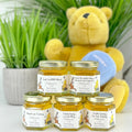 Jars of honey with personalized labels in front of a teddy bear and plant