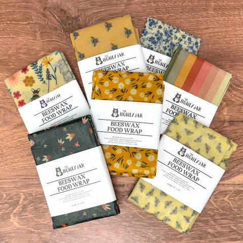 Collection of colorful beeswax food wraps on a wooden surface