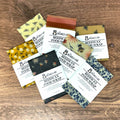 Collection of beeswax food wraps with floral and patterned designs on a wooden surface