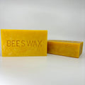 2 blocks of yellow unfiltered beeswax. One standing up and one laying on its side