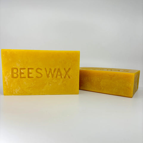 2 blocks of yellow unfiltered beeswax. One standing up and one laying on its side