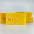 Four blocks of yellow unfiltered beeswax stacked