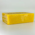 Single block of yellow unfiltered beeswax laying on its side