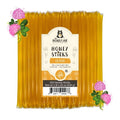 Pack of Honey Sticks with a label on a white background, surrounded by clover flowers.