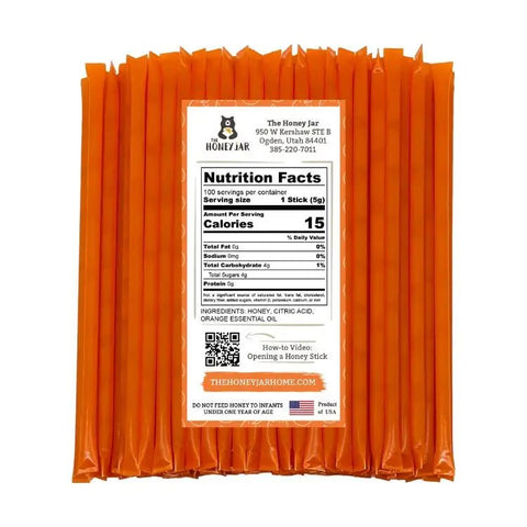 Packaging of orange honey sticks with a label on a white background