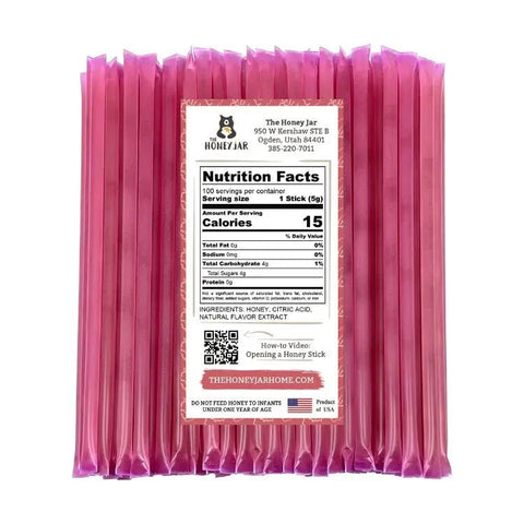 Pack of pink honey sticks with a label on a white background