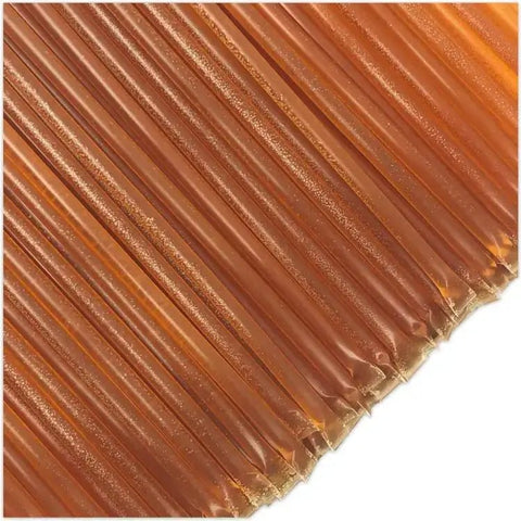 Close-up of dark gold honey sticks on white background