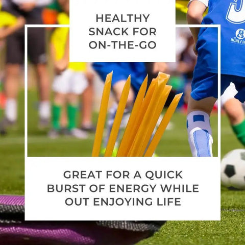 Snack sticks in a container with soccer players in the background on a grass field.