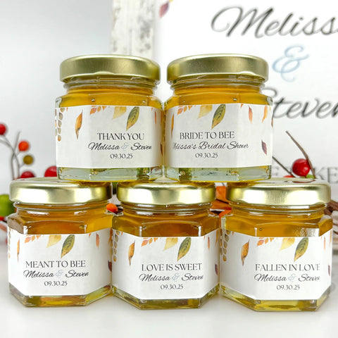  Small honey jars with personalized labels in front of blurred background