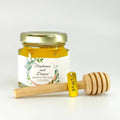 2 oz hexagon jar filled with honey, gold lid, 3" wooden honey dipper, gold love charm, and personalized leaf frame label with spread the love title.