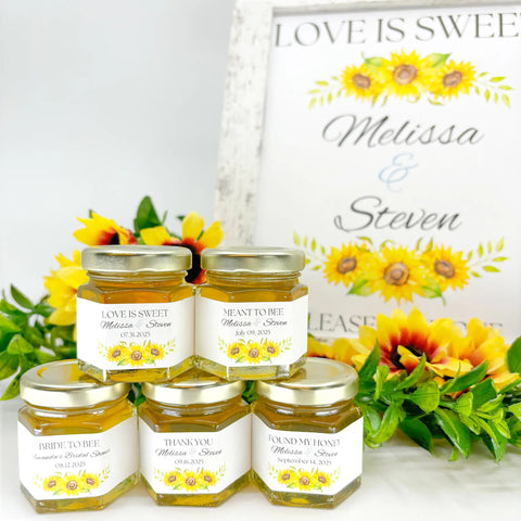 Honey jars with 'Love is Sweet' labels on a white surface with sunflower decorations.
