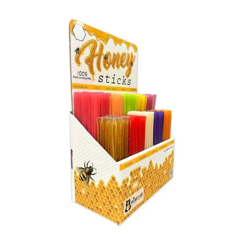 Box of honey sticks with colorful packaging on a white background